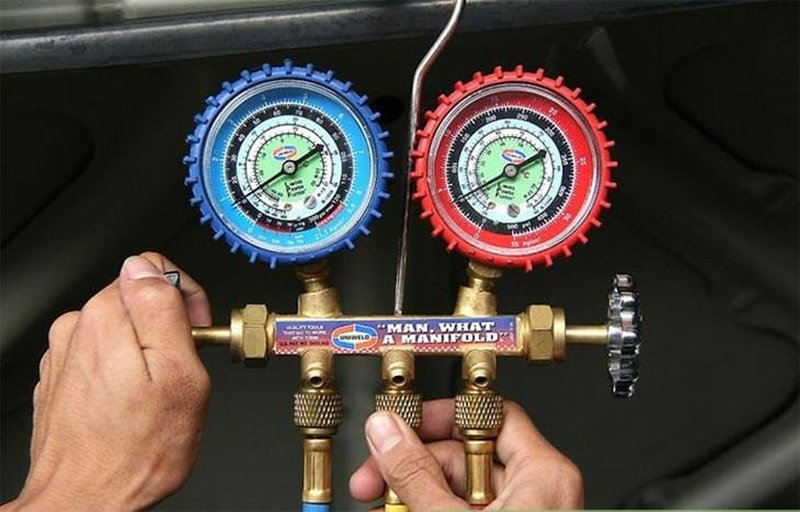Thợ sửa chữa máy lạnh chuyên nghiệp dùng đồng hồ đo áp suất gas máy lạnh