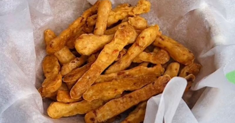 Cheese stick vàng giòn hấp dẫn sau khi chiên, đặt trong giấy nến