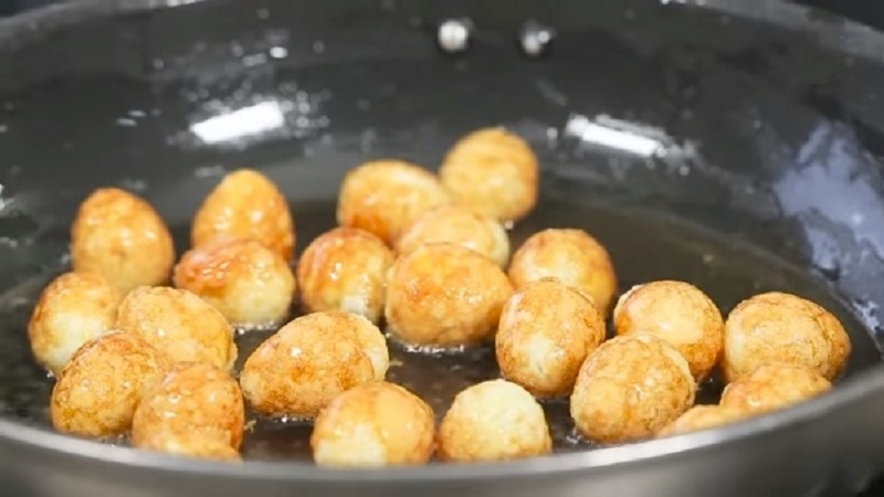 Chiên vàng giòn trứng cút trong chảo dầu