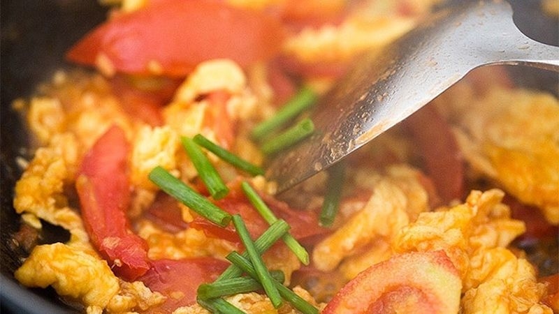 Xào trứng với cà chua và hành lá trong chảo
