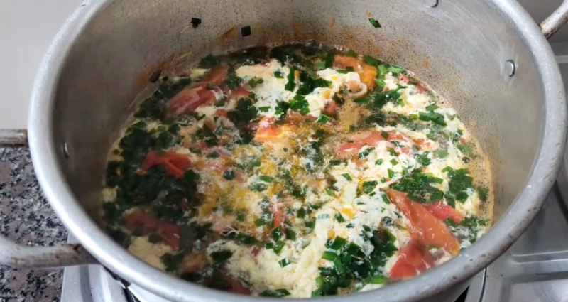 Nồi canh hẹ trứng cà chua đang sôi trên bếp thơm ngon