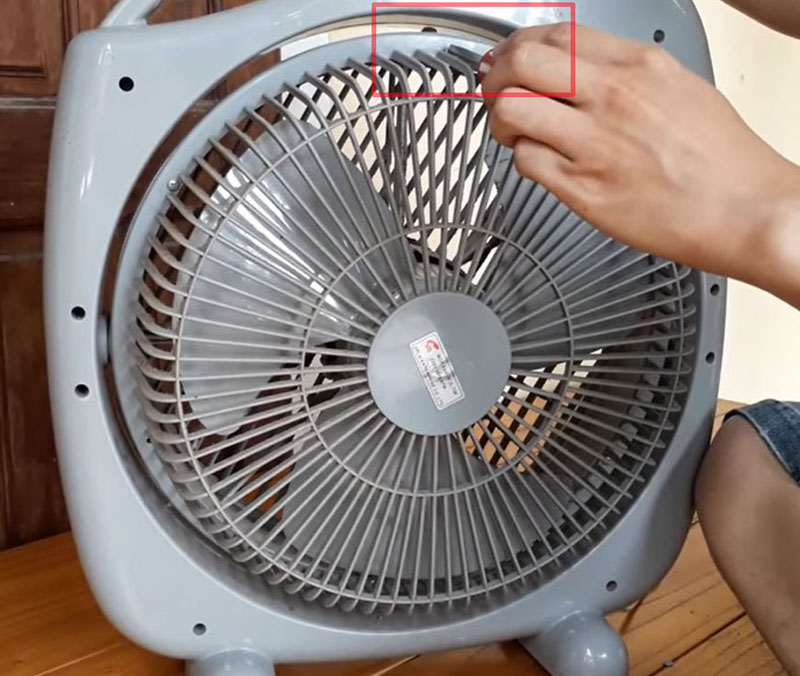 Dùng tua vít vặn nhẹ để tháo rời phần lồng quạt phía sau
