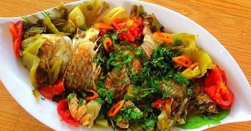 Cá chép om dưa cải chua với cà chua và rau thơm