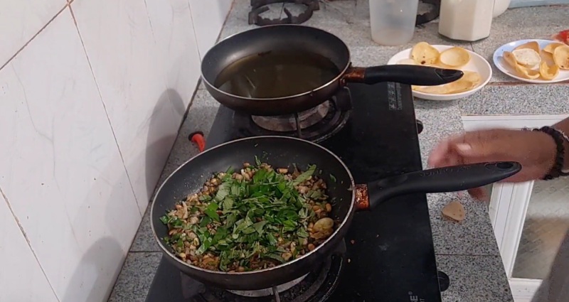 Cho phần rau răm vào chảo hến xào