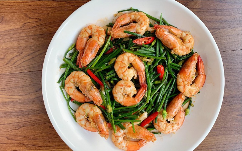 Tôm xào bông hẹ đựng trên đĩa trắng