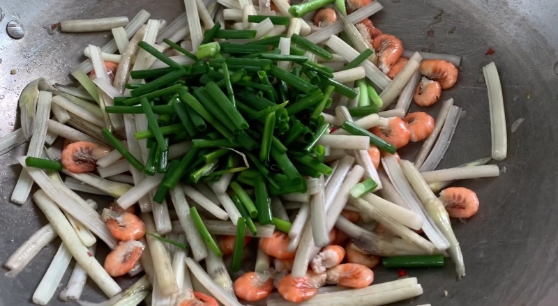 Thêm hành lá vào chảo ngó sen xào tôm