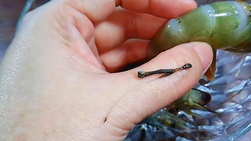 Giữ chặt đầu tôm và từ từ kéo tách ra khỏi thân