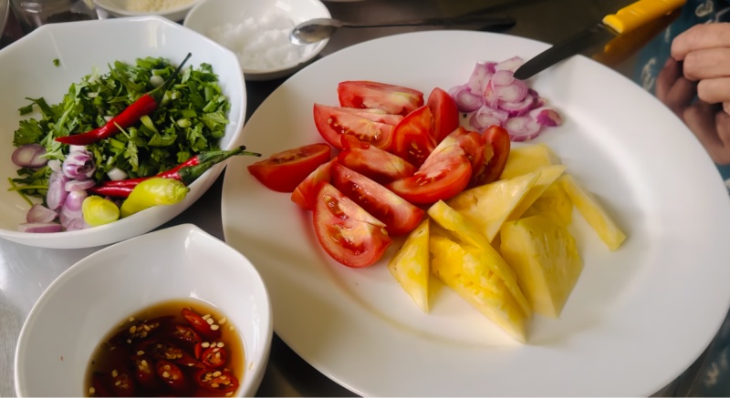 Sơ chế nguyên liệu nấu bún cá chim gồm cà chua, dứa và hành tím