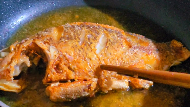 Chiên cá chép vàng đều trước khi nấu sốt cà chua