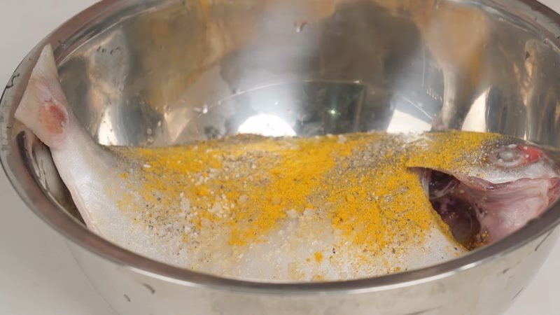Ướp cá chim với gia vị để nấu cá chim sốt cà chua