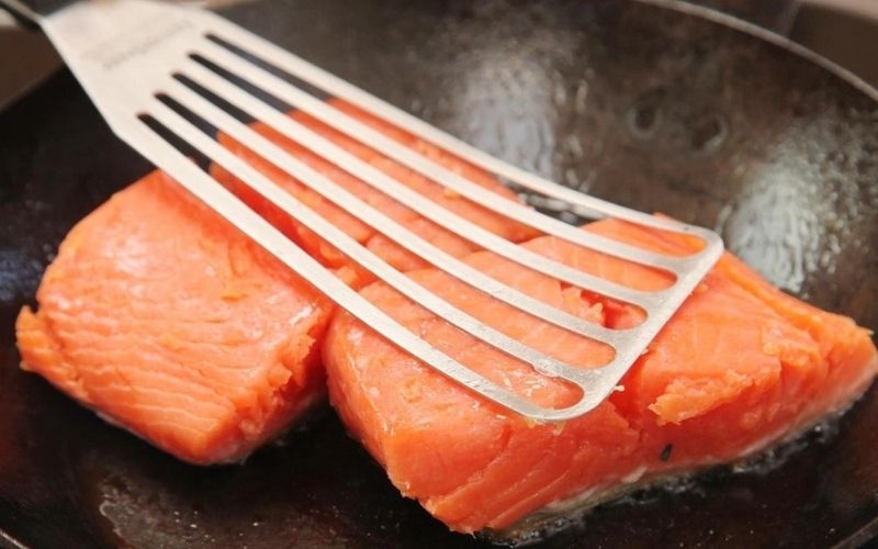 Cá hồi được chiên vàng ươm trên chảo