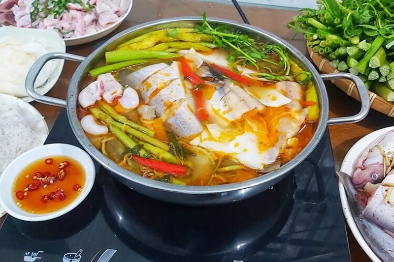 Nồi lẩu cá lóc măng chua đầy đủ cá lóc, măng và rau ăn kèm