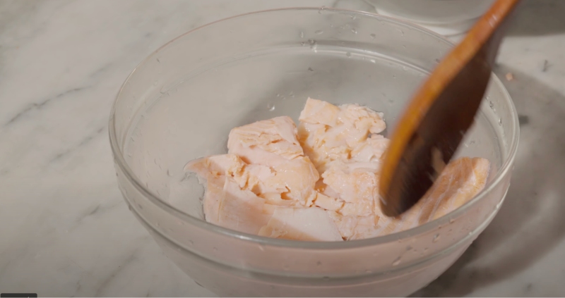 Cá hồi hấp chín được dằm nhỏ chuẩn bị cho món cháo cá hồi hạt sen