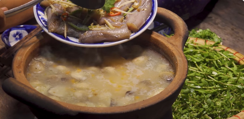 Cháo cá khoai nấu trong nồi đất, múc ra tô