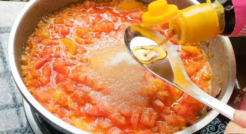 Nêm nước mắm vào nồi sốt cà chua