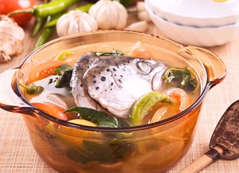 Canh chua xương cá hồi nấu với cà chua, dọc mùng và rau thơm