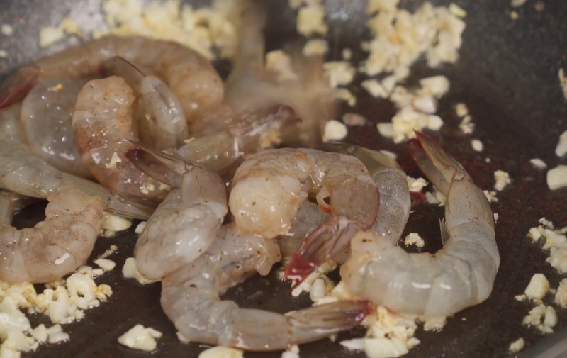 Xào tôm với tỏi băm trên chảo