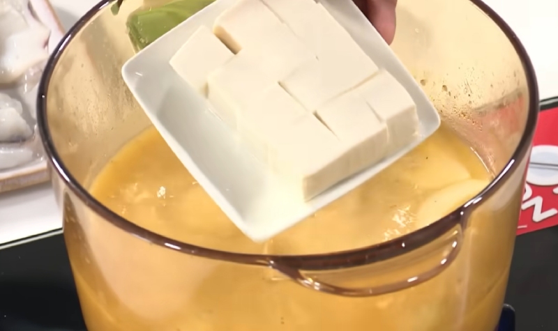 Cho đậu hũ cắt miếng vào nồi nước lẩu