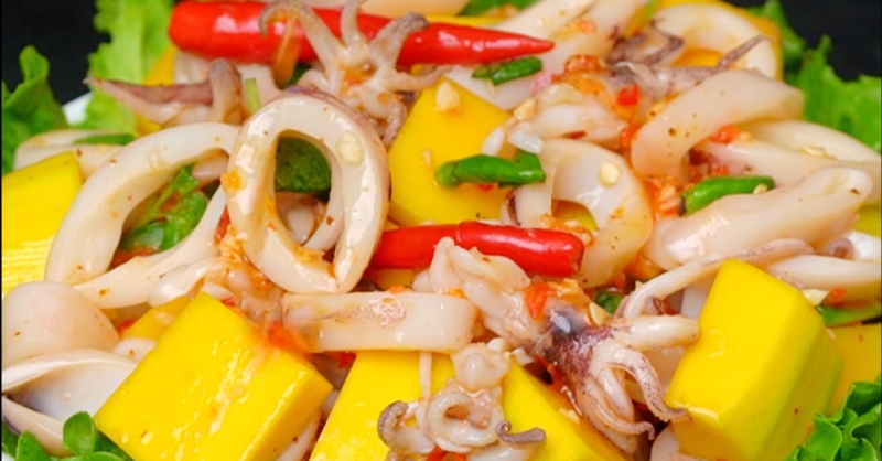 Thành phẩm mực sốt Thái bày ra đĩa, trang trí với hành lá, ngò rí và ớt cắt lát