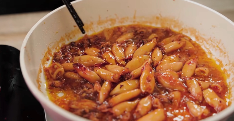 Đảo đều mực sữa với nước sốt mắm tỏi trong chảo cho thấm vị