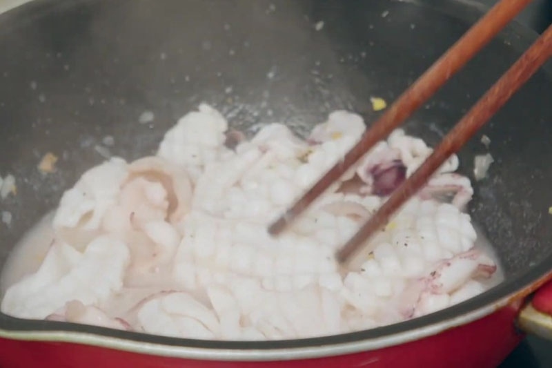 Mực tươi xào sơ trong chảo chuẩn bị cho món mực xào mướp