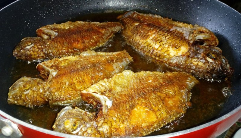 Chiên giòn cá rô phi trên chảo dầu