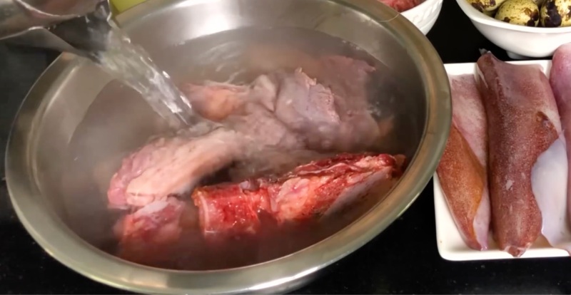 Công đoạn sơ chế xương heo với nước sôi