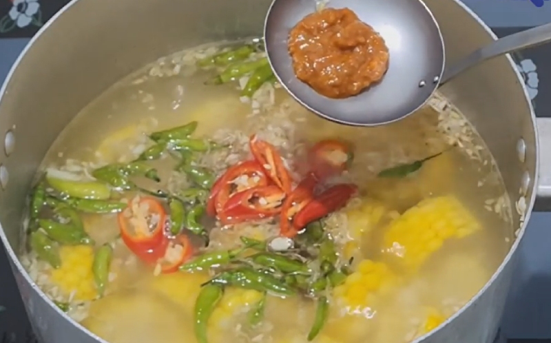 Nồi nước lẩu với ớt và gia vị được cho vào