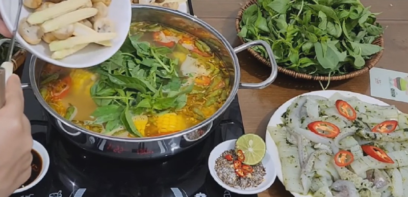 Cho nấm và lá é vào nồi lẩu mực