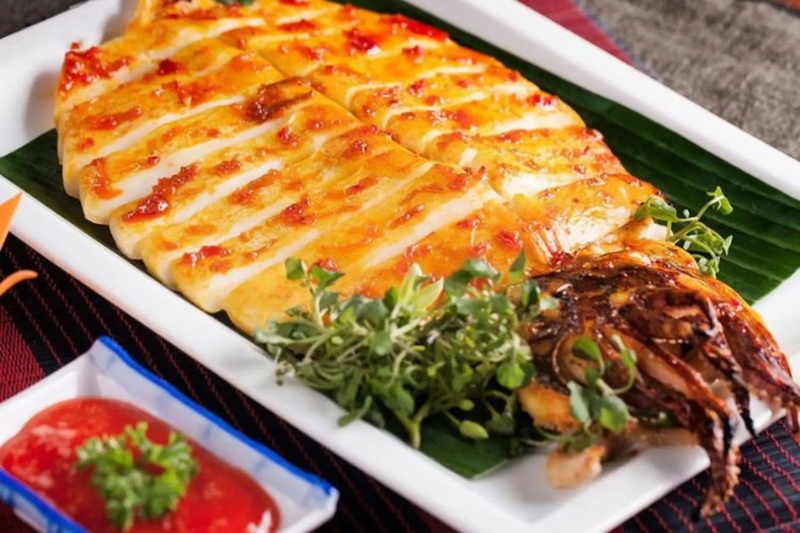 Mực một nắng nướng chín, bày ra đĩa cùng chén tương ớt