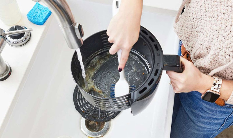 Làm sạch rổ chiên và khay chiên bằng bàn chải mềm