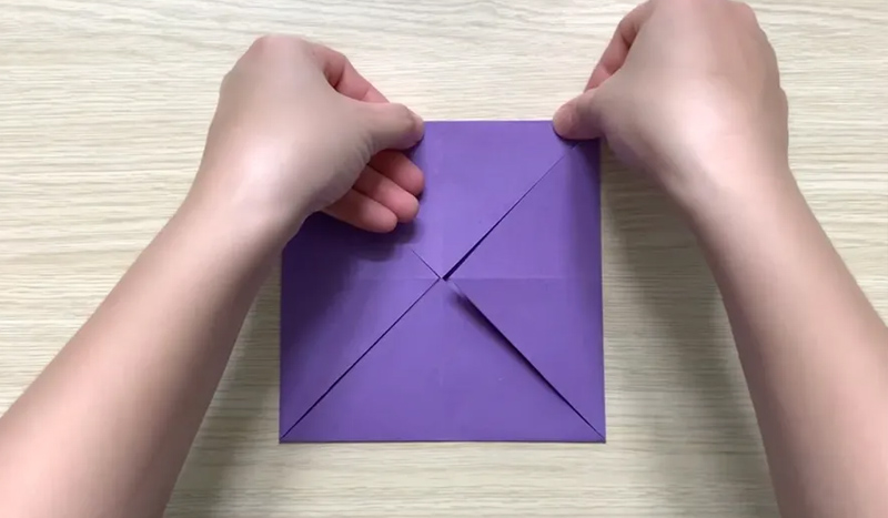 Gấp các góc hình vuông vào trong nếp gấp đã đánh dấu