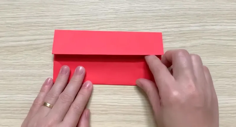 Gấp nửa phần cạnh dưới và cạnh trên vào đường chính giữa