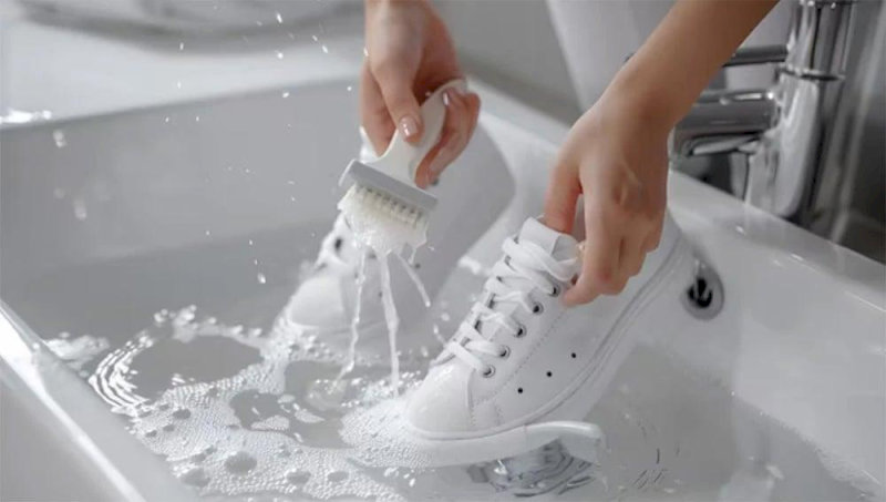 Hãy xịt sơ giày dưới vòi nước mạnh để loại bỏ bùn đất, đá nhỏ kẹt ở đế giày
