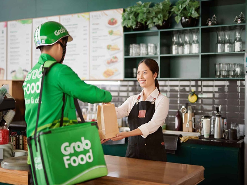 Shipper GrabFood nhận đồ ăn từ nhân viên nhà hàng