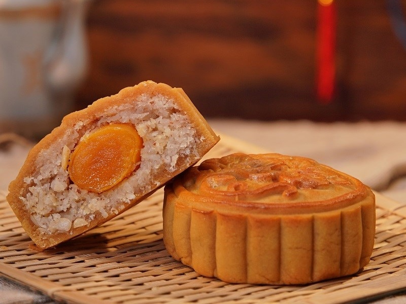 Bánh Trung thu nhân dừa trứng muối cắt đôi trên mâm tre