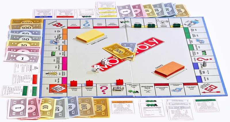 Bàn cờ Monopoly với tiền giấy, xúc xắc, thẻ cơ hội và bất động sản