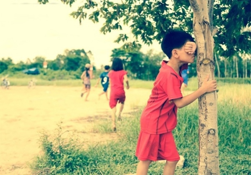 các bạn nhỏ chơi trò trốn tìm trên cánh đồng