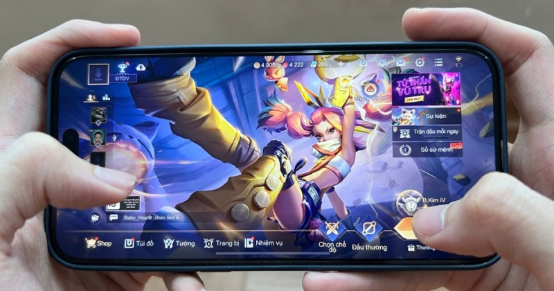 Người chơi đang cầm điện thoại chơi game Liên Quân Mobile