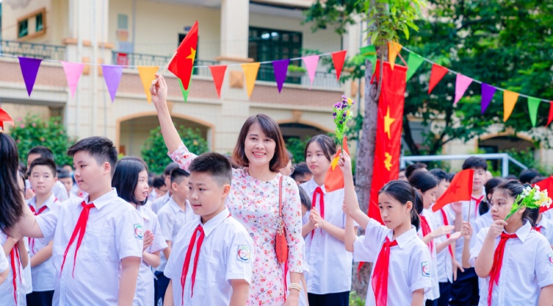 Cô giáo cùng học sinh phất cờ
