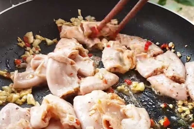 Lòng heo đang được xào với tỏi ớt trên chảo