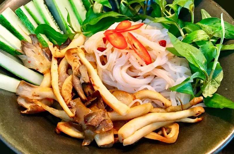 Rưới nước sốt đã pha lên tô bún trộn chay nấm