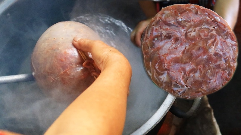Luộc nguyên trái chả bong bóng heo sau khi nhồi.