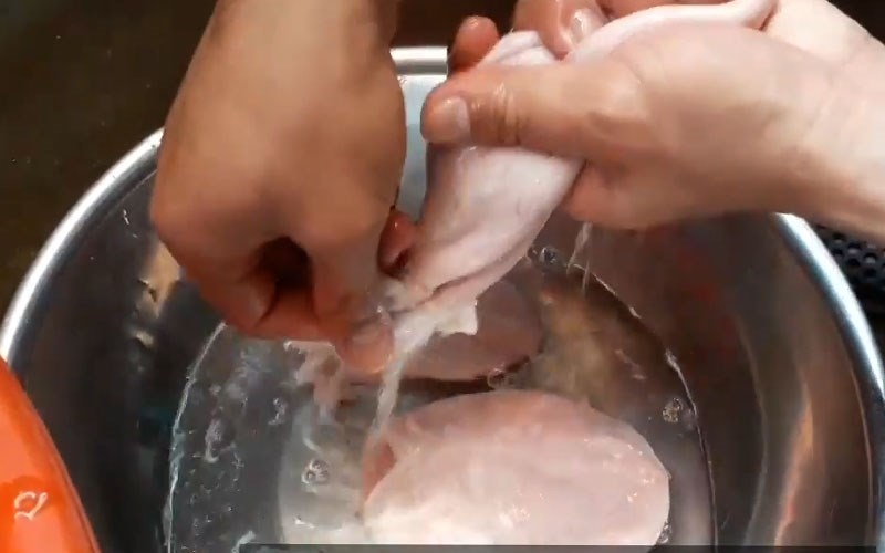 Rửa sạch bong bóng heo bằng tay với nước.