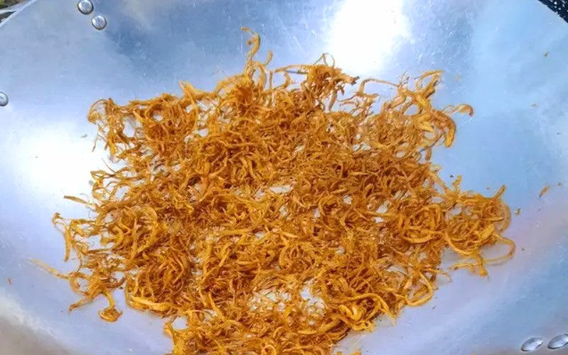 Đặt nấm đã xé sợi vào chảo để sấy khô