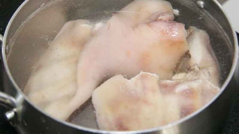 Tai heo, mũi heo và da heo đang luộc sơ trên bếp