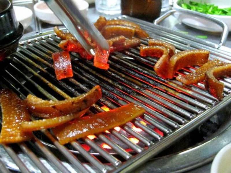 Da heo đang được nướng trực tiếp trên bếp than hồng