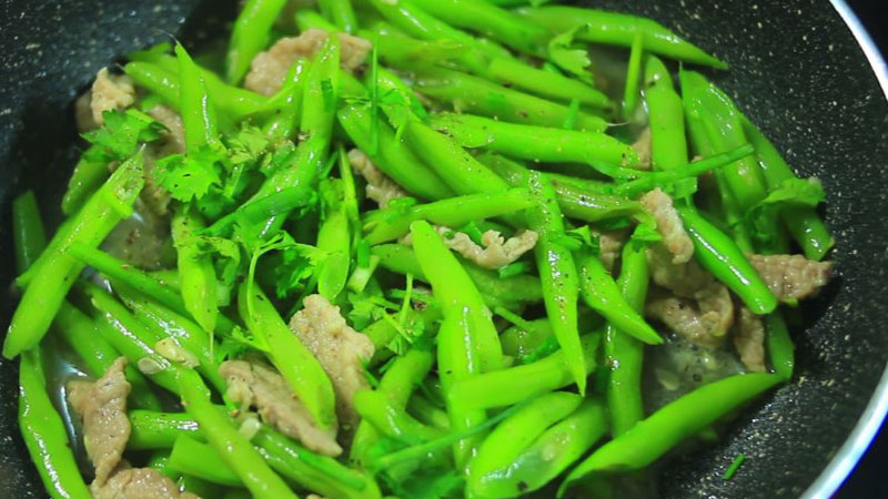 Khi đậu ve xào thịt chín, trang trí thêm hành ngò