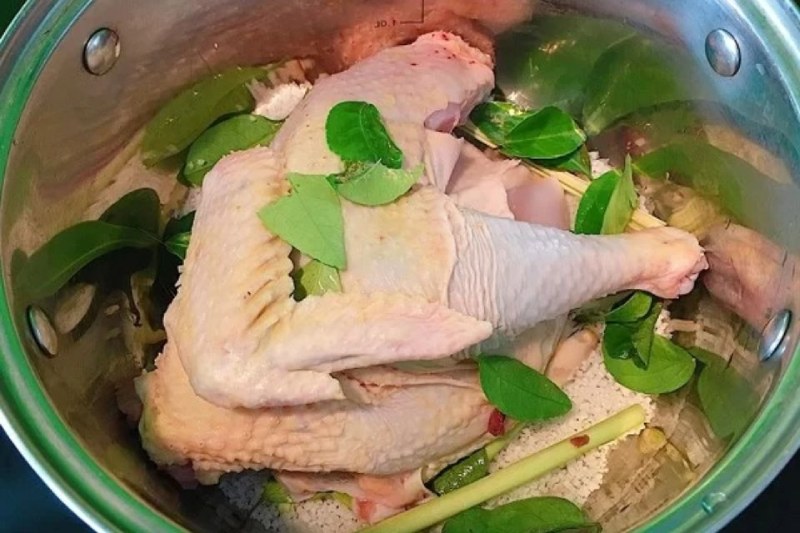  Trải một lớp lá chanh rồi đặt gà lên hấp