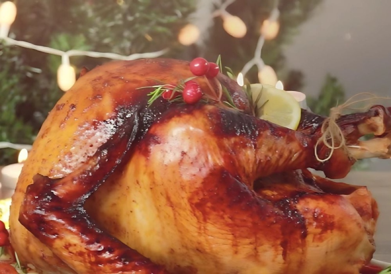 Gà nướng Giáng Sinh vàng óng trang trí với chanh và quả mọng